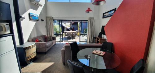a living room with a table and a couch at The Moorings Motel and Apartments in Wanaka
