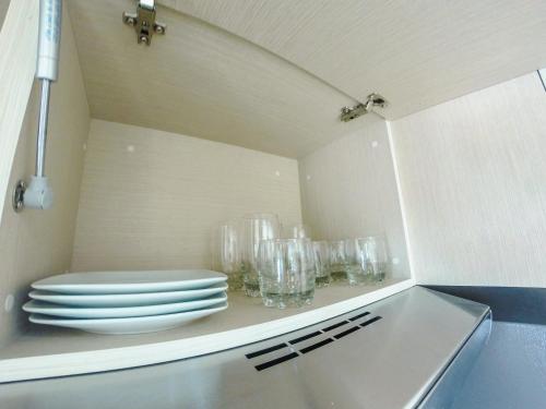 a kitchen with plates and glasses on a shelf at Hospedaje Tlaquepaque in Guadalajara