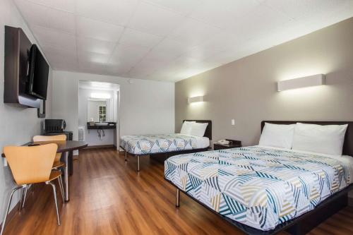 a hotel room with two beds and a desk at Motel 6-Walterboro, SC in Walterboro
