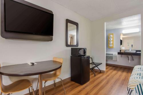 a room with a table and a flat screen tv at Motel 6-Walterboro, SC in Walterboro