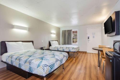 a hotel room with two beds and a flat screen tv at Motel 6-Walterboro, SC in Walterboro