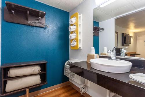 a bathroom with a sink and a blue wall at Motel 6-Walterboro, SC in Walterboro