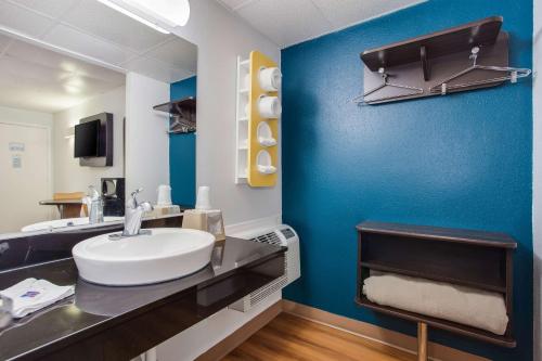 a bathroom with a white sink and a blue wall at Motel 6-Walterboro, SC in Walterboro