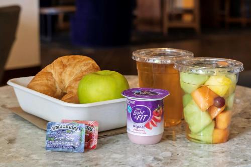 a table with a bowl of fruit and a bowl of bread at Hyatt Place Greenville/Haywood in Greenville