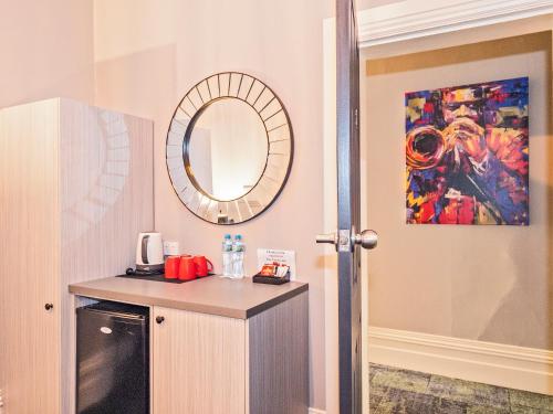 a bathroom with a mirror and a counter with a sink at Telegraph Hotel Numurkah in Numurkah