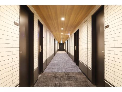a corridor of a hallway with black and white walls at Smile Hotel Shonan Fujisawa in Fujisawa