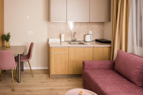 a living room with a couch and a kitchen at Urban Residence Apartments in Mostar