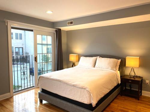 Un dormitorio con una cama con dos lámparas y un balcón. en Alina & Fanny - Philadelphia 1212 Mt Vernon St, en Filadelfia