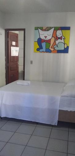 a bed in a room with a painting on the wall at Pousada Centro e Praia in Fortaleza