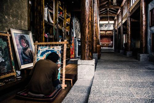 a person sitting on a chair in an art shop at Arro Khampa By Zinc Journey Shangri-la in Shangri-La