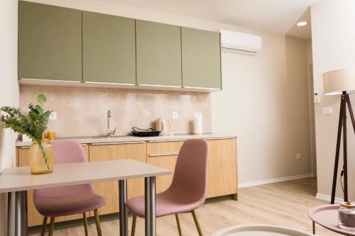 a kitchen with pink chairs and a table at Urban Residence Apartments in Mostar