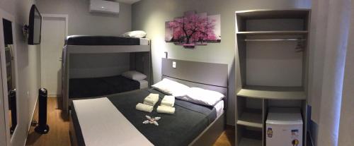 a small room with two bunk beds in it at Mirante dos Anjos Suítes in Arraial do Cabo