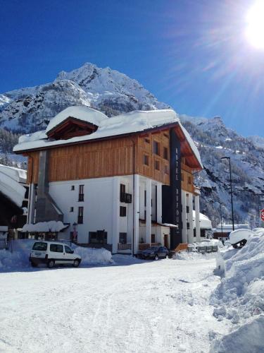 a building in the snow with a mountain in the background at Hotel Dufour in Gressoney-la-Trinité