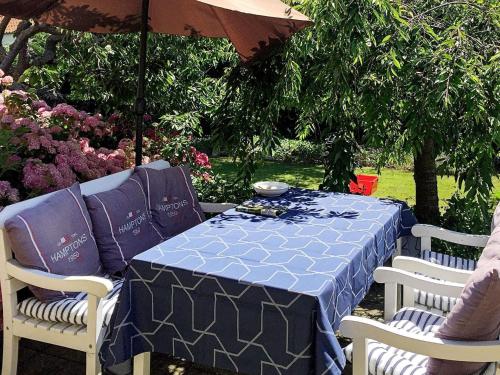 stół i dwa krzesła z niebieskim stołem i parasolem w obiekcie 8 person holiday home in Rudk bing w mieście Rudkøbing