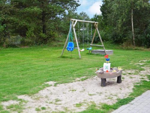 a park with a playground with a swing at 12 person holiday home in R m in Bolilmark