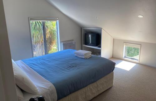 a bedroom with a large bed and a tv at The Barn in Lake Tekapo