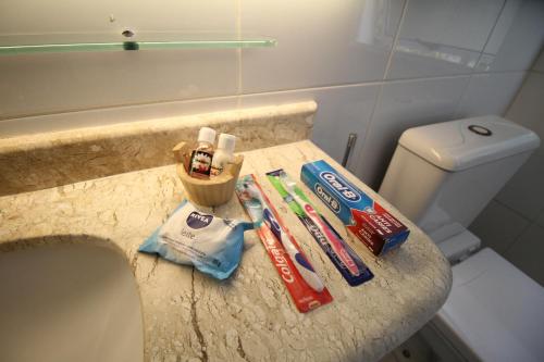 a bathroom with toothbrushes and toothpaste on a counter at Suites em Juquei in Juquei