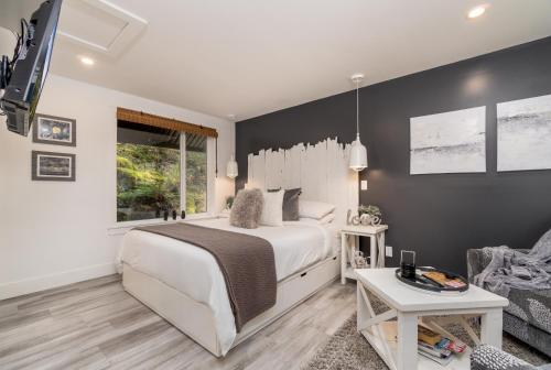 een slaapkamer met een wit bed en een bank bij Amante Luxury Bed & Breakfast in Victoria