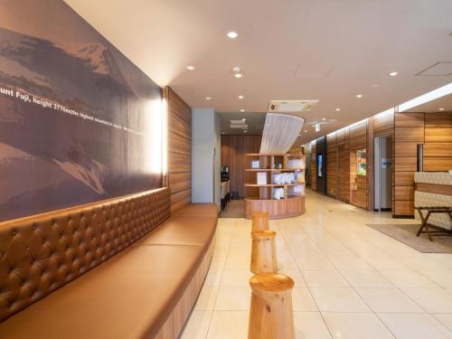 a lobby with a large painting on the wall at Super Hotel JR Fujiekimae Kinenkan in Fuji