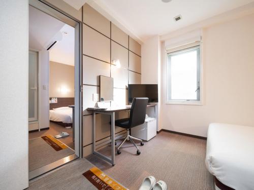 a hotel room with a desk and a mirror at Super Hotel JR Fujiekimae Kinenkan in Fuji