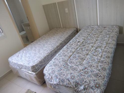 two beds sitting next to each other in a room at Vista para o mar in Guarujá