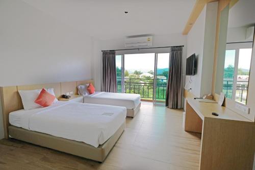 een hotelkamer met 2 bedden en een balkon bij Sleeping Tree Hotel in Fang