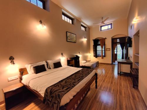 a bedroom with a large bed and a desk at Hotel Mount View Heritage in Panchgani