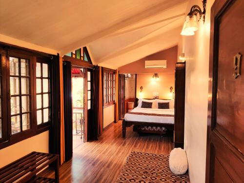 a bedroom with a bed in the middle of a room at Hotel Mount View Heritage in Panchgani