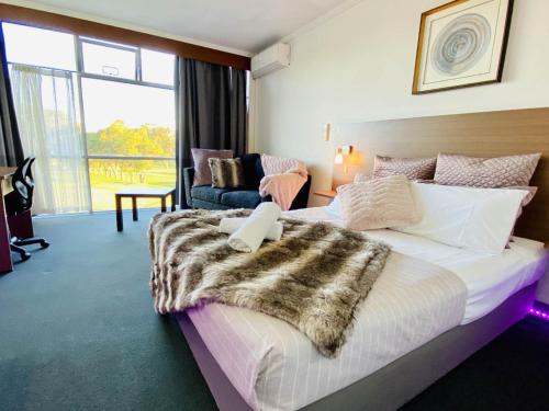 a hotel room with a bed with a fur blanket on it at The Select Inn Ryde in Sydney