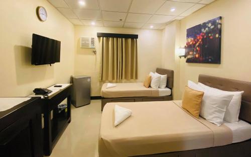 a hospital room with two beds and a tv at Amax Inn Makati in Manila