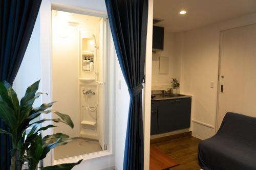 Habitación con baño pequeño con ducha. en Higashi Shinagawa Apartment, en Tokio