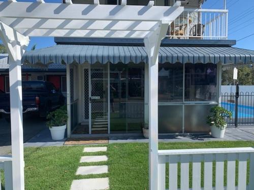 a white pergola in front of a house at Classic Motel in Gold Coast