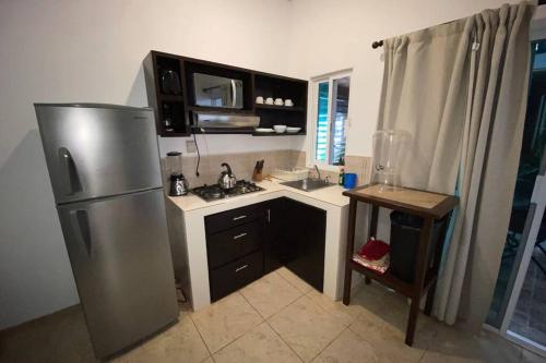 a small kitchen with a refrigerator and a sink at Chacala Arrecifes 2 para 4 a solo 50 mts de la Playa ARF2 in Chacala