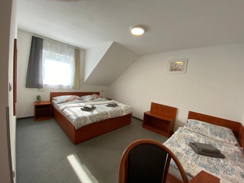 1 Schlafzimmer mit 2 Betten, einem Tisch und Stühlen in der Unterkunft Penzion Hornička in Český Krumlov