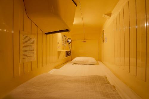a room with a bed and a lamp in it at Capsule Land Yushima (Male Only) in Tokyo
