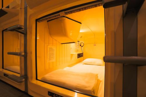 東京的住宿－湯島膠囊旅館（只限男性），一间小房间,里面设有两张床