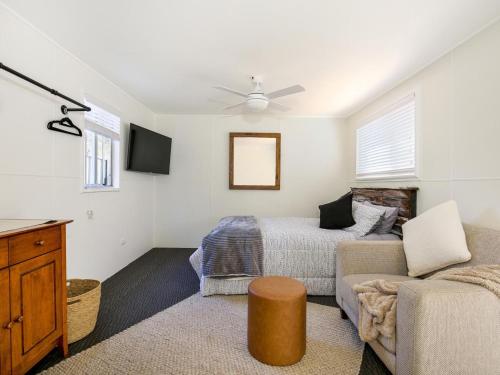 a living room with a bed and a couch at Pagoda at Culburra I Pet Friendly I Newly Renovated in Culburra Beach