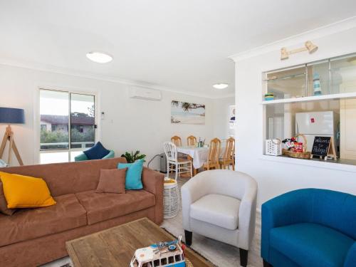 a living room with a couch and a table at Palms I Pet Friendly I 2 Mins to Beach in Culburra Beach