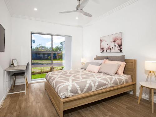 a bedroom with a bed and a window at Callies Retreat I Pet Friendly I 3 Min Walk to Beach in Callala Beach