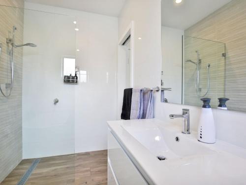 a white bathroom with a sink and a shower at Callies Retreat I Pet Friendly I 3 Min Walk to Beach in Callala Beach