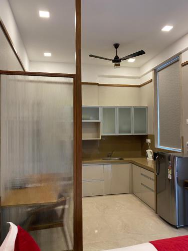 a kitchen with white cabinets and a stainless steel refrigerator at Theory9 Premium Service Apartments Khar in Mumbai