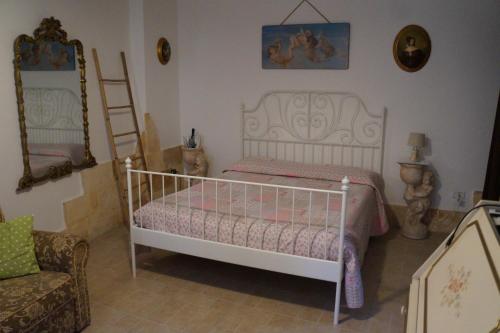 a bedroom with a white bed and a chair at L'atmosfera in Brindisi