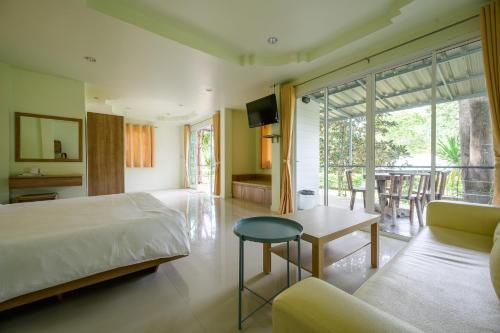 una camera da letto con un letto, un tavolo e un divano di Yura Kiri Resort Khao Yai a Mu Si