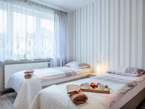 a bedroom with two beds and a tray of food at Willa Lawenda in Ciechocinek
