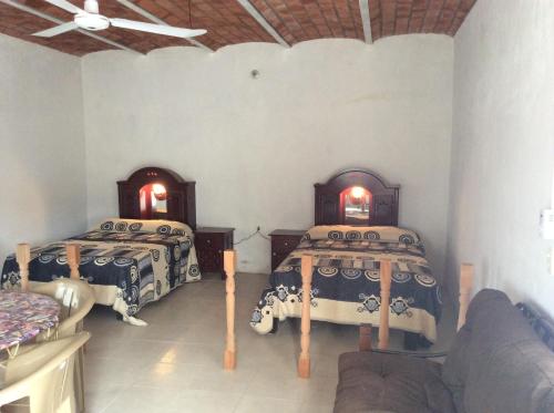 een kamer met 2 bedden en een bank bij Casa de descanso en Santa Cruz in Tepic
