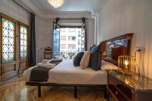 - une chambre avec un grand lit et une fenêtre dans l'établissement HiHome Hostel, à Oviedo