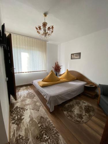 a bedroom with a bed and a couch and a chandelier at Vila Lilica in Bran