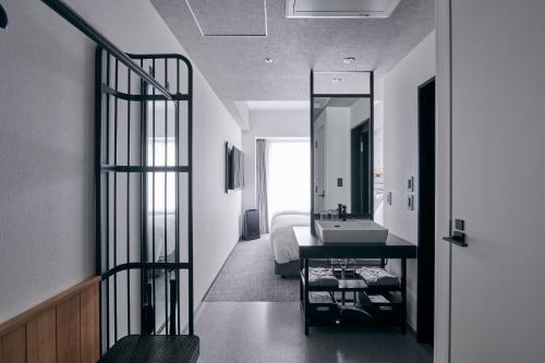 a bathroom with a sink and a bed with a mirror at ibis Styles Nagoya in Nagoya