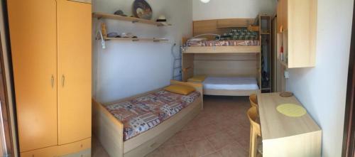 um pequeno quarto com um beliche e uma mesa em Estella Mare em Letojanni