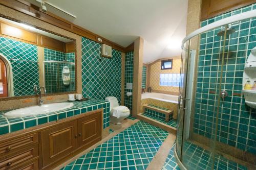 a bathroom with green tiled walls and a sink and a shower at Ruen Ariya Resort in Mae Rim